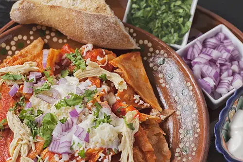Red Chilaquiles with Chicken served with bread